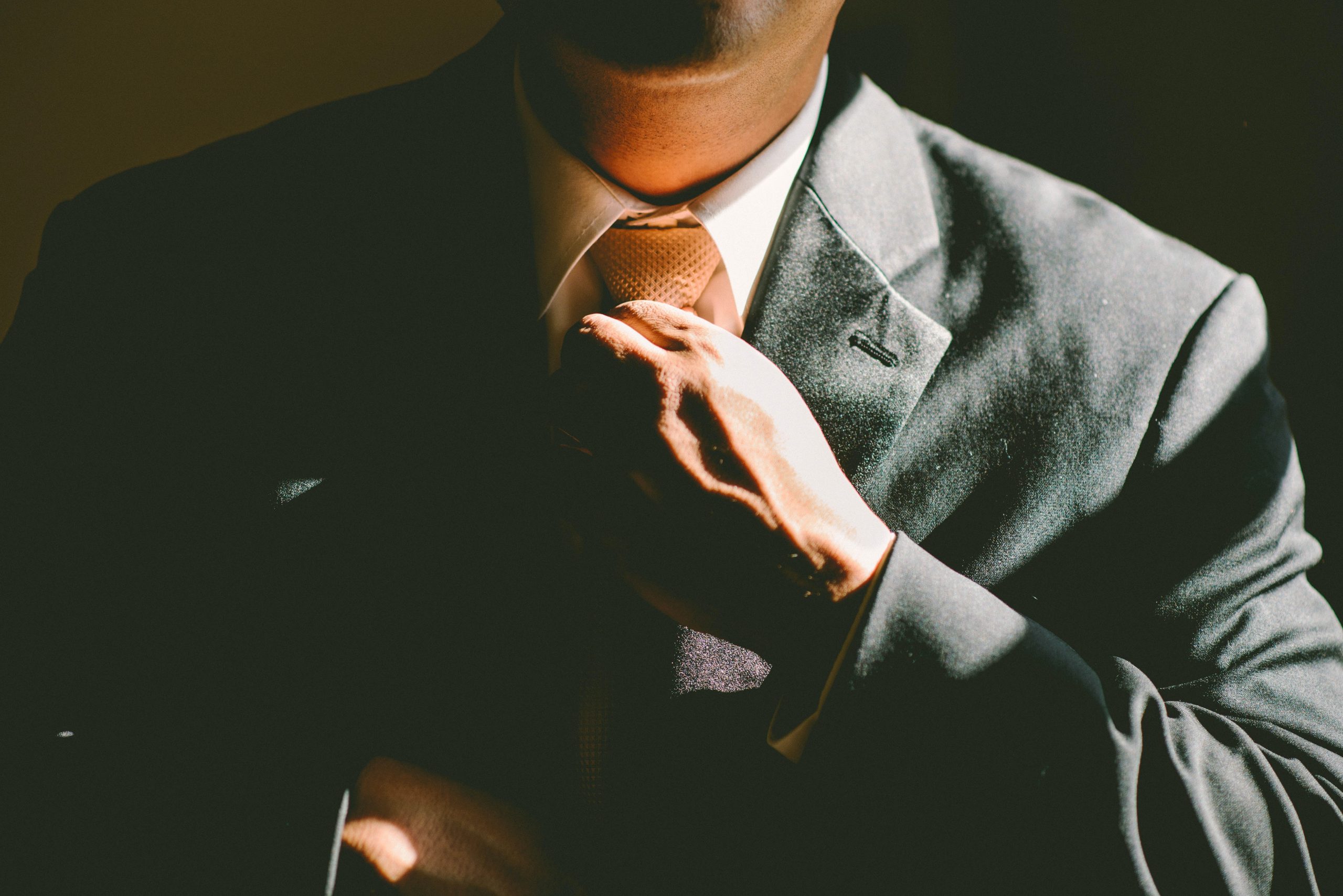 Corporate man adjusting his tie