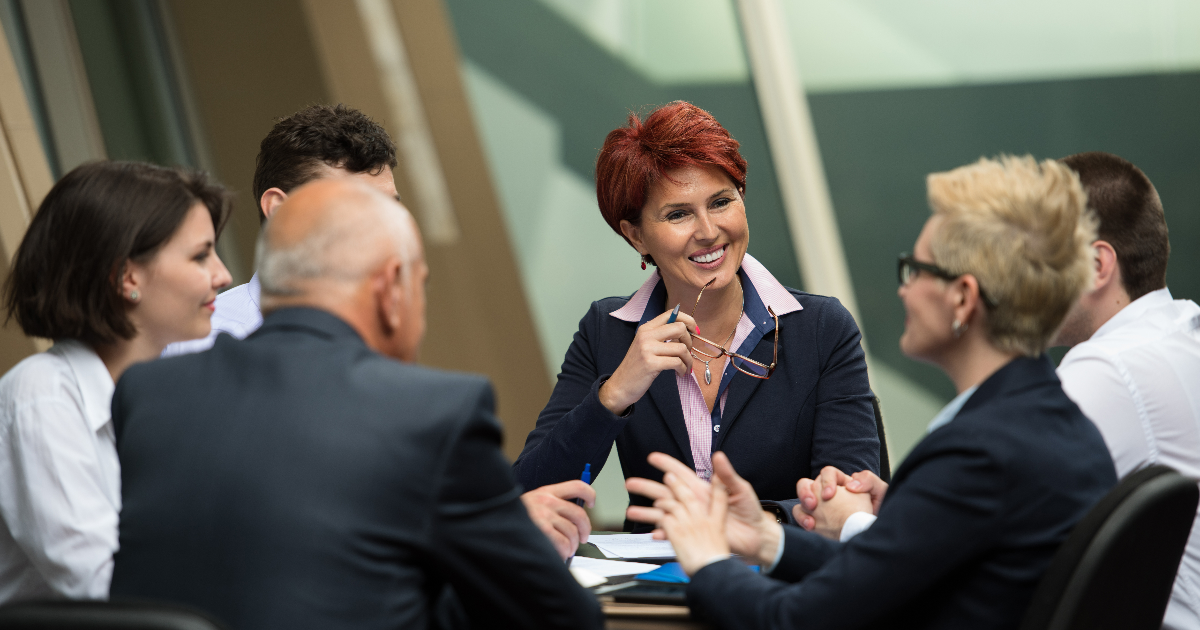 Business professionals smiling during a board meeting