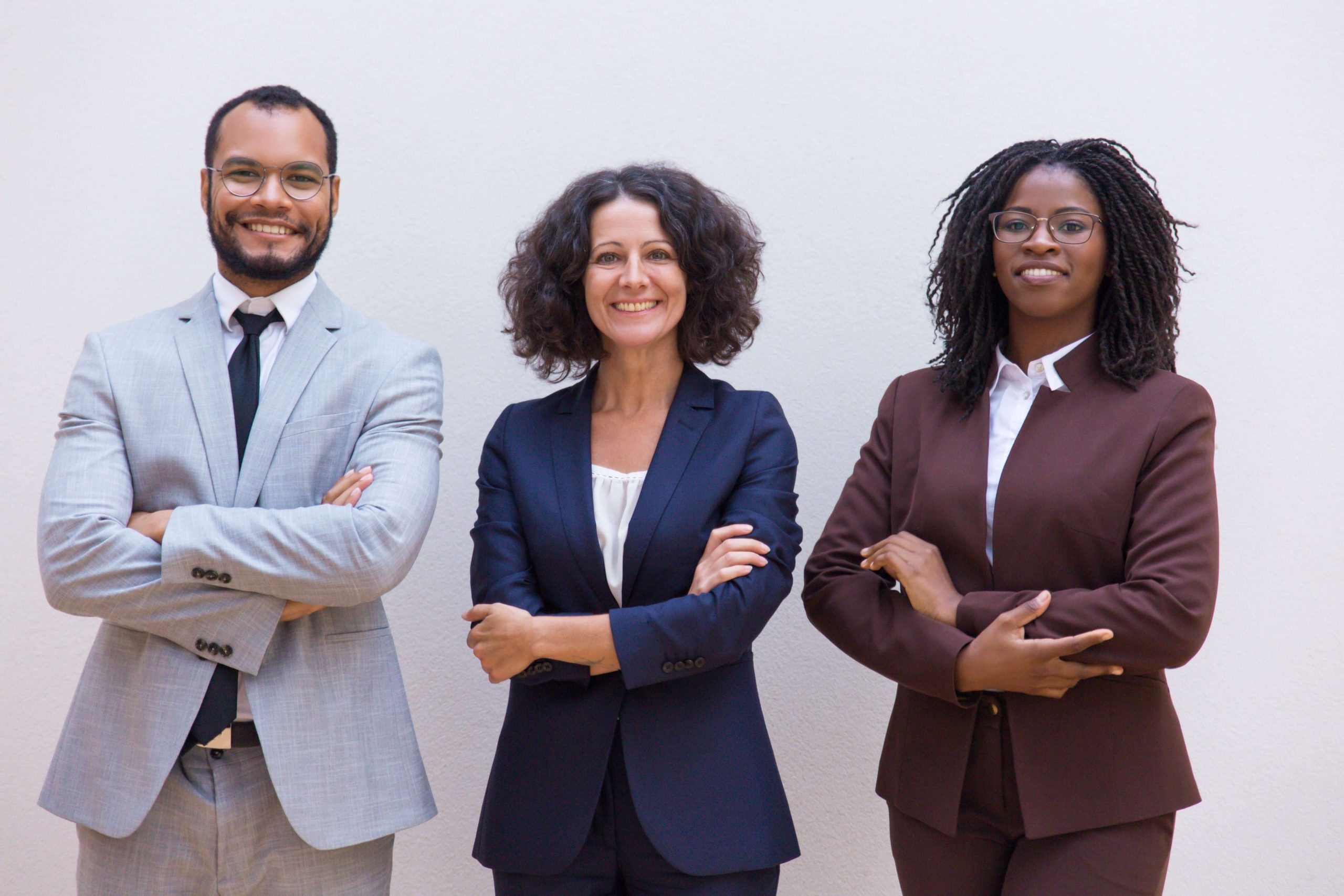 Small group of diverse board members smiling and standing side-by-side